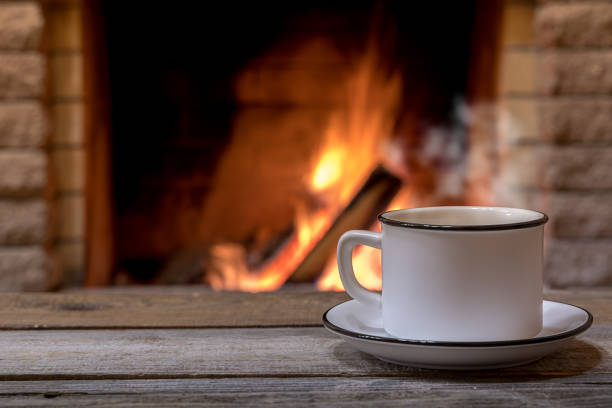 Cozy fireplace and a cup of tea, in country house, winter vacation. stock photo