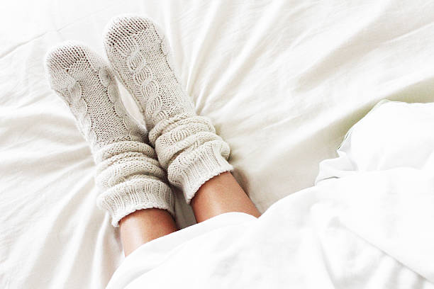 Cozy socks Warm and cozy white socks in the bed sock stock pictures, royalty-free photos & images
