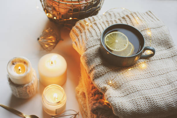 Cozy winter morning at home. Hot tea with lemon, knitted sweaters and modern metallic interior details. Still life composition, danish hygge concept stock photo