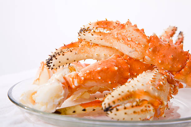 Crab Legs A pile of fresh crab legs on a white background. animal limb stock pictures, royalty-free photos & images