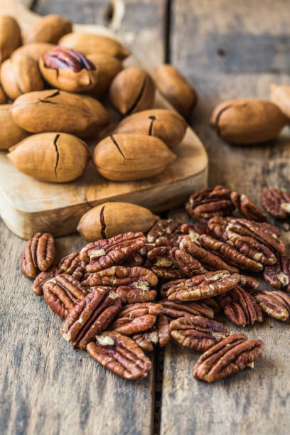 Cracked and opened pecan nuts and nuts in shell. stock photo
