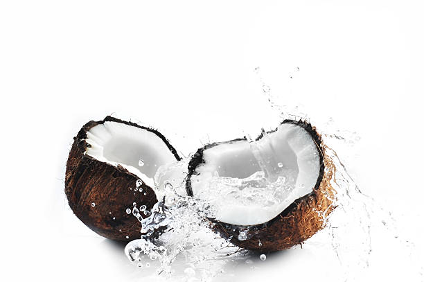 Cracked coconut splashing on white background stock photo