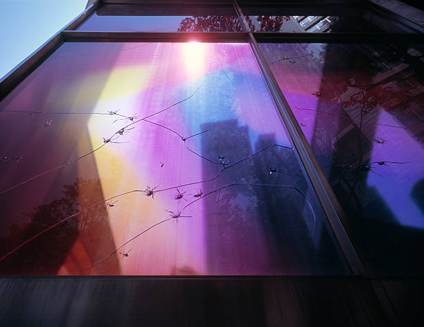 cracked window with colorful foil - raam folie stockfoto's en -beelden