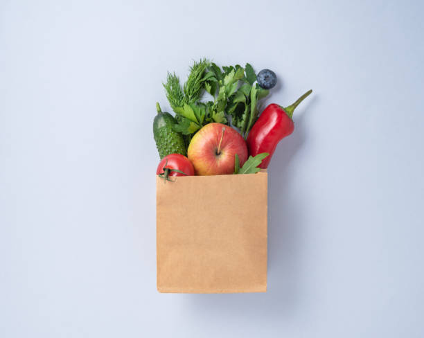 craft bag with fresh vegetables and fruits on a blue background - paper bag craft imagens e fotografias de stock