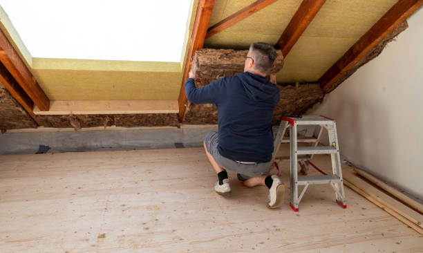 Craftsman putting insulation material to the attic. stock photo