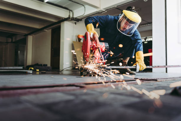 Craftsman Welding is Cutting Steel Work in Fabrication Workshop, Welder Man in Safety Protective Equipments Doing Metalwork in Construction Site. Steel Labor Skill and Workshops Production Concept stock photo