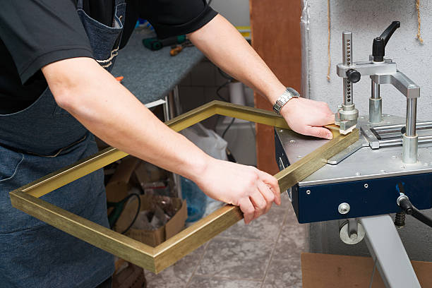 Craftsman working on frame in frameshop. Professional framer. Top view. Craftsman working on frame in frameshop. Professional framer hand holding frame angle. Top view. craftsperson photos stock pictures, royalty-free photos & images