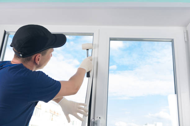 craftsmen in protective gloves, fixes a double-glazed window with a plastic baseboard, hammering it with a rubber mallet, against a blue sky - plastic hammers imagens e fotografias de stock