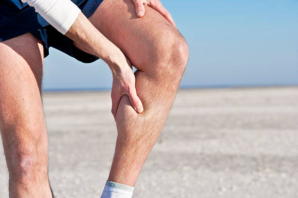 Cramp in calf "A male jogger, having a cramp in his calf." cramp stock pictures, royalty-free photos & images