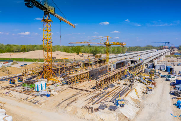 Cranes in the construction of a bridge for a highway. Aerial view stock photo