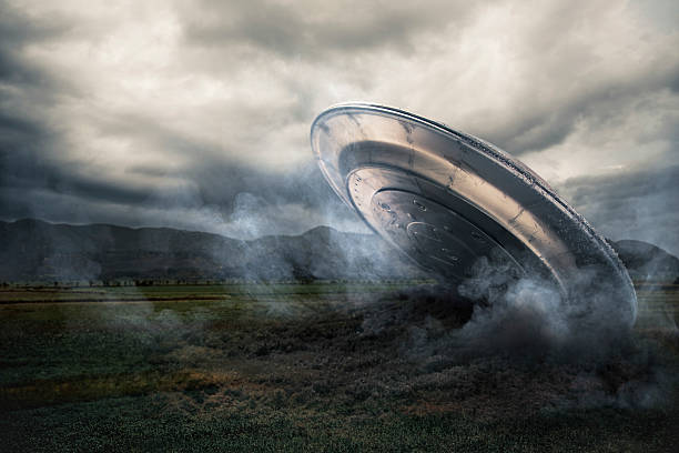 UFO crashing on a crop field UFO crash on a field with smoke alien photos stock pictures, royalty-free photos & images