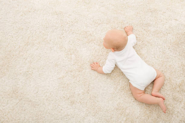 Crawling Baby on Carpet Background, Kid Top View, Newborn Child on Beige Blanket Crawling Baby on Carpet Background, Infant Kid Top View, Newborn Child Lying on Beige Blanket crawling stock pictures, royalty-free photos & images