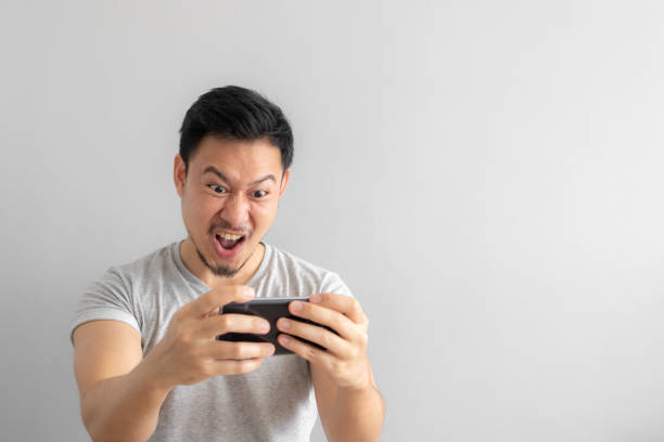 Crazy and funny face of man addicted to mobile game. stock photo