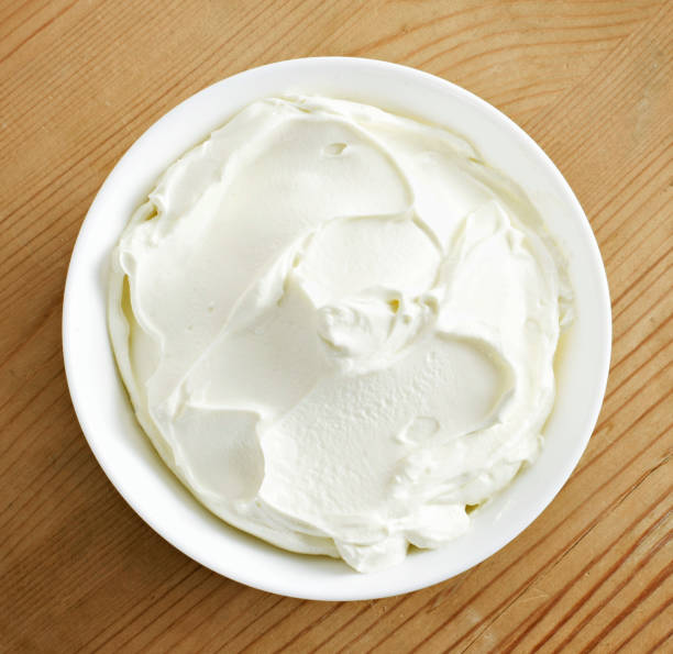Cream cheese, quark or yogurt in a white bowl stock photo