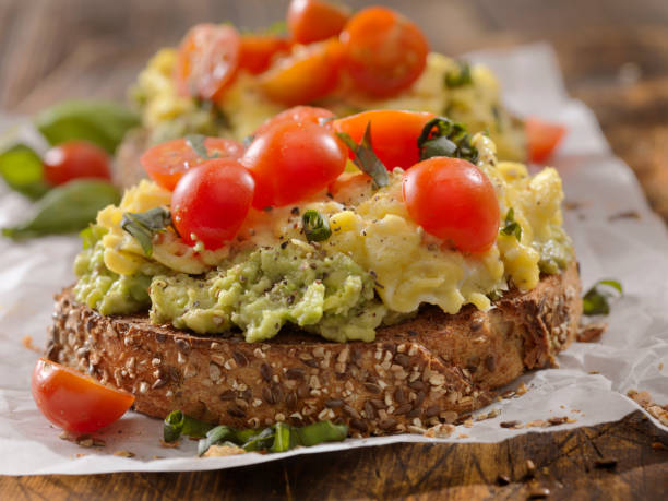 Creamy Avocado Sandwich with Scrambled Eggs and Tomatoes Creamy Avocado Sandwich with Scrambled Eggs and Tomatoes toasted bread stock pictures, royalty-free photos & images