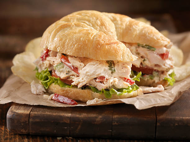 Creamy Chicken Salad on a Croissant "A Creamy Chicken Salad Sandwich with Red Peppers, Cucumber, Lettuce and Tomato on a Croissant and Potato Chips on the side- Photographed on Hasselblad H3D2-39mb Camera" chicken salad stock pictures, royalty-free photos & images