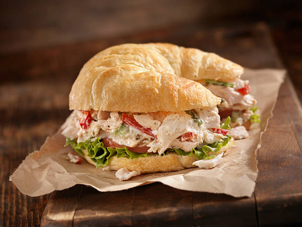 Creamy Chicken Salad on a Croissant "A Creamy Chicken Salad Sandwich with Red Peppers, Cucumber, Lettuce and Tomato on a Croissant - Photographed on Hasselblad H3D2-39mb Camera" chicken salad stock pictures, royalty-free photos & images