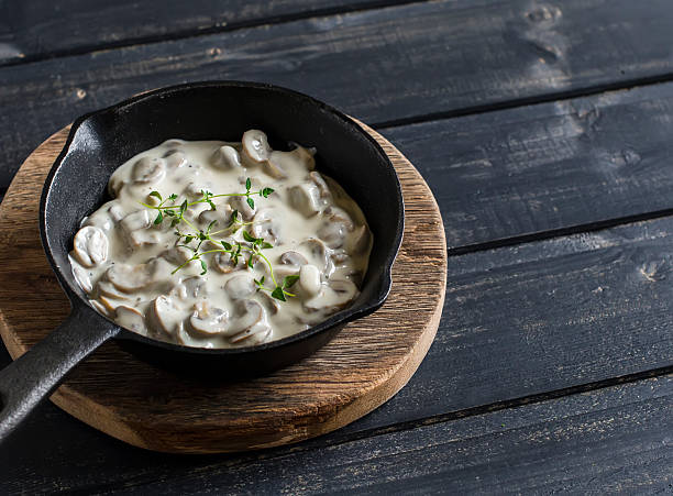 Creamy mushroom sauce in a pan on a wooden rustic board stock photo