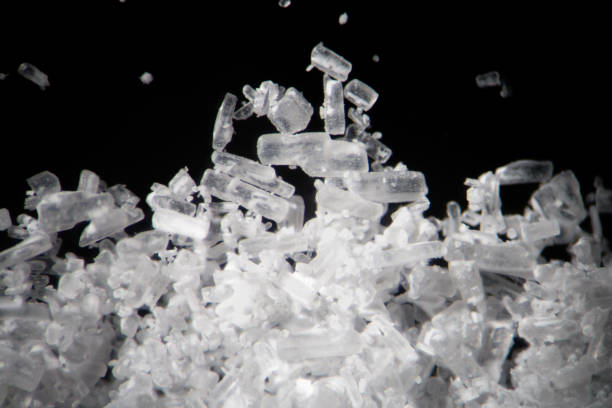 Creatine crystals by microscope. Athletic dietary supplement in details supermacro close-up. White cristales on black background or low key Creatine crystals are used by athletes as a dietary supplement. Creatine is a nitrogenous organic acid. Its main role is to facilitate recycling of adenosine triphosphate (ATP), the energy currency of the cell, primarily in muscle and brain tissue amphetamine stock pictures, royalty-free photos & images