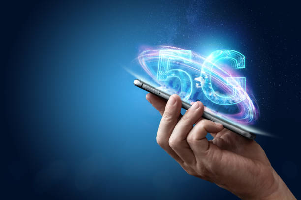 Creative background, male hand holding a phone with a 5G hologram on the background of the city. The concept of 5G network, high-speed mobile Internet, new generation networks. Copy space, Mixed media. stock photo