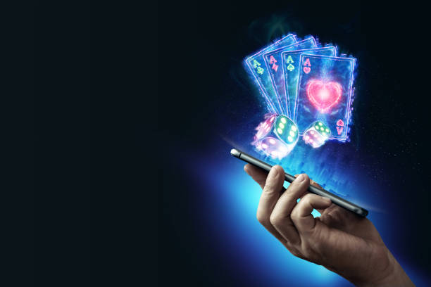 Creative background, online casino, in the male hand a smartphone with playing neon cards, neon background. Internet gambling concept. Copy space stock photo