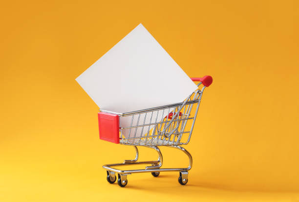 Creative shopping background with shopping cart and empty card Creative shopping background with shopping cart and empty card in it on yellow background with copy space. Black friday or sale minimal concept mockup. market retail space photos stock pictures, royalty-free photos & images