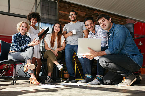Creative team meeting to discuss professional project Team of creative professionals meeting in office. Multiracial group of young designers working together for a new project. business casual stock pictures, royalty-free photos & images