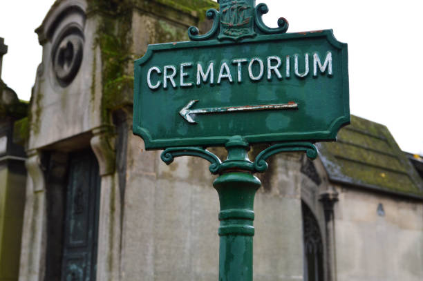 Crematorium for a funeral cremation A direction sign in a cemetery, which gives the direction of a crematorium for a funeral cremation and funeral service. funerary urn stock pictures, royalty-free photos & images