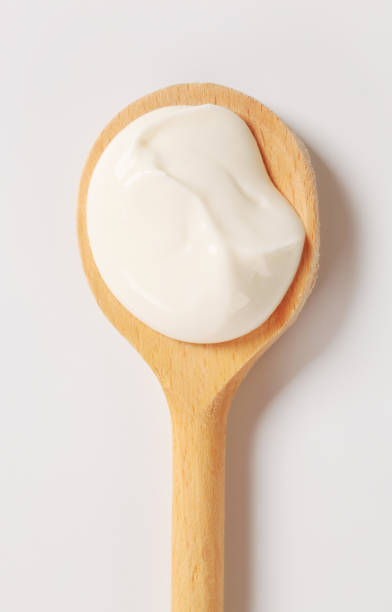Creme fraiche on wooden spoon Creme fraiche on a wooden spoon cream dairy product stock pictures, royalty-free photos & images