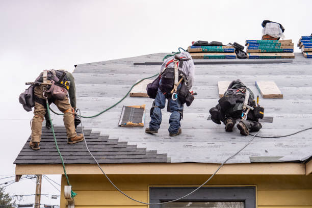 Crew Installing New Shingles on Roof on a Rainy Day stock photo