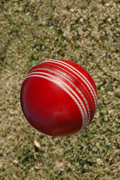 Cricket ball spinning against grass stock photo