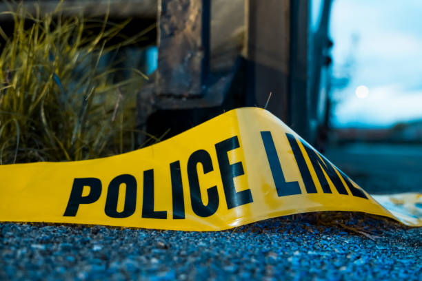 Crime scene investigation, police do not cross, yellow boundary tape Barricade police tape on the floor at a shooting crime scene gun violence stock pictures, royalty-free photos & images