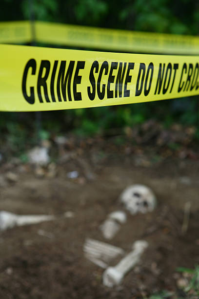 Crime Scene Crime Scene tape with human remains in background. Shallow focus on tape. serial killer stock pictures, royalty-free photos & images