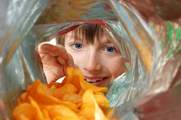 Crisp Monster Boy eager to get to his Crisps... unhealthy eating photos stock pictures, royalty-free photos & images