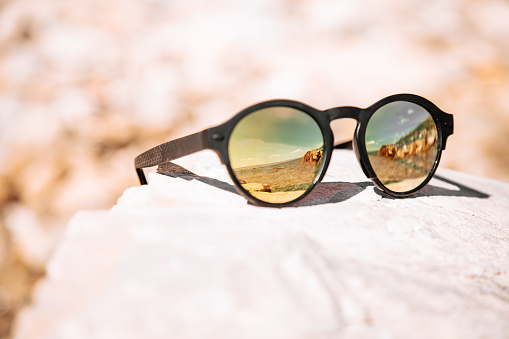Sunny croatian mediterranean beach mirroring in black sunglasses. Selective Focus Detail Shot. Dalmatia, Croatia, Southeast Europe.
