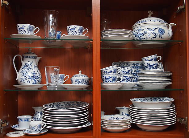 Crockery in wooden kitchen cabinet Mugs, cups and plates with blue and white pattern of flowers and onions. All neatly cleaned up in a wooden kitchen cabinet. porcelain stock pictures, royalty-free photos & images