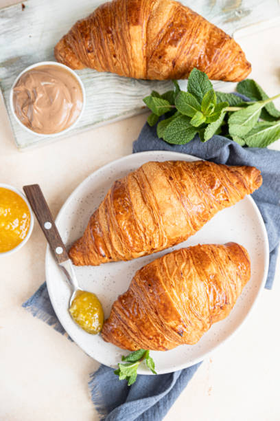 Croissants with jam and chocolate cream, light concrete background. Top view. stock photo