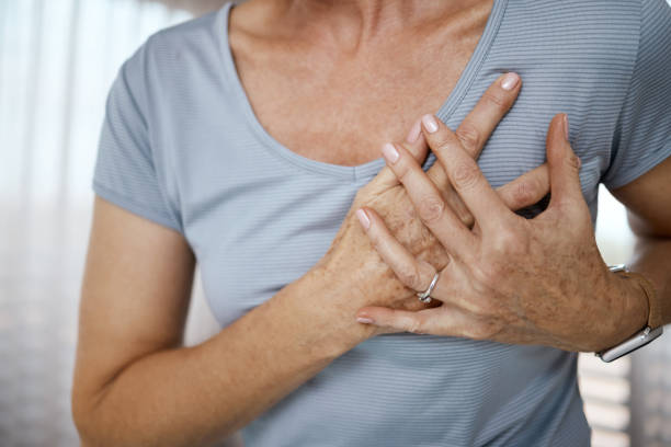cropped closeup of an unrecognizable woman experiencing cardiac discomfort at home - medelålders kvinna bröstsmärtor bildbanksfoton och bilder