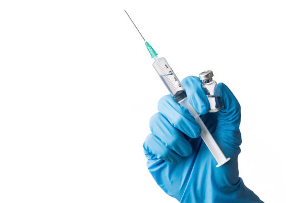 Cropped hand with medical glove holds a vial and a syringe as a vaccination concept, isolated on white background stock photo