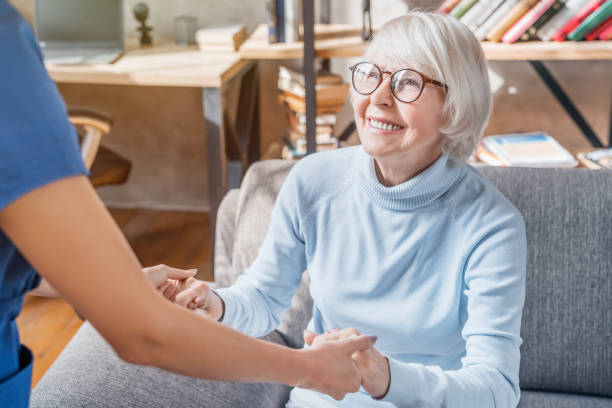 Cropped image of female professional caregiver taking care of elderly woman at home Senior Adult, Nurse, Patient, Care, Assistance elderly care stock pictures, royalty-free photos & images