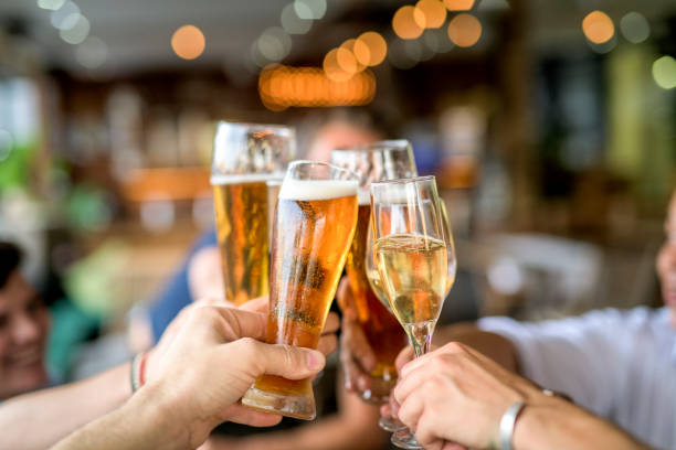 Cropped image of friends toasting drinks in celebration. stock photo