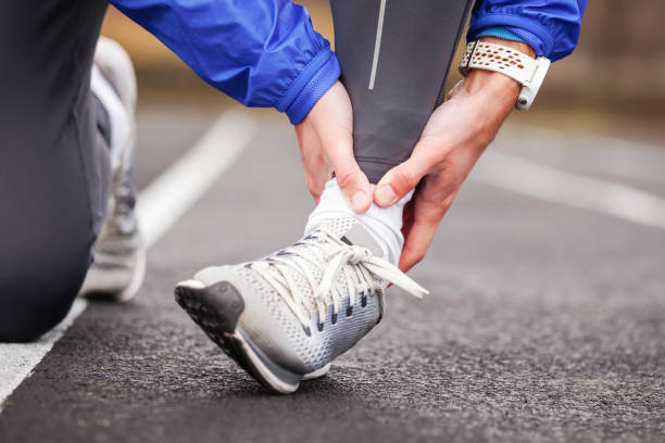 Cropped shot of a young man holding his ankle in pain sprain a foot. Cropped shot of a young man holding his ankle in pain while running. ankle stock pictures, royalty-free photos & images