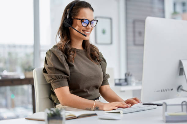 Cropped shot of an attractive young female call center agent working at her desk in the office stock photo