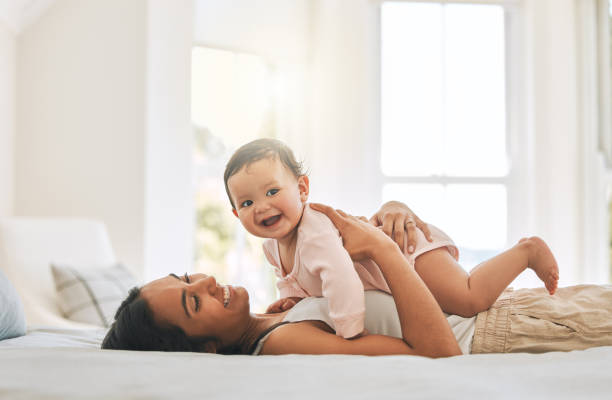 Cropped shot of an attractive young woman and her newborn baby at home stock photo