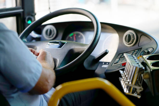 cropped shot of bus driver holding steering whee Hands of driver in a modern bus by driving.Concept - close-up of bus driver steering wheel and driving passenger bus school bus driver stock pictures, royalty-free photos & images