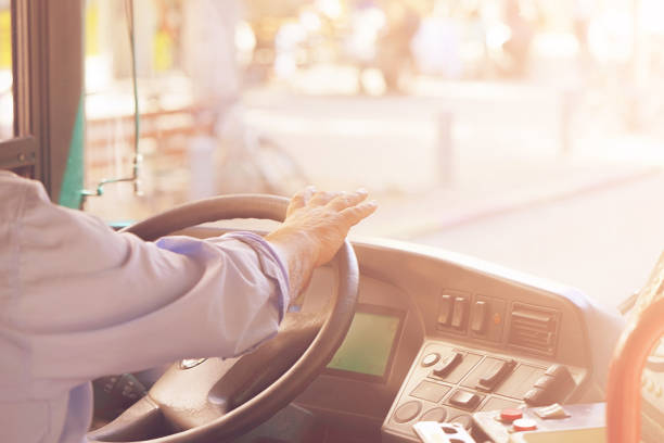 cropped shot of bus driver holding steering whee Hands of driver in a modern bus by driving.Concept - close-up of bus driver steering wheel and driving passenger bus. Toning school bus driver stock pictures, royalty-free photos & images