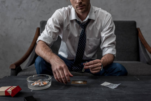 cropped shot of young businessman with drug addiction preparing to take cocaine cropped shot of young businessman with drug addiction preparing to take cocaine snorting stock pictures, royalty-free photos & images