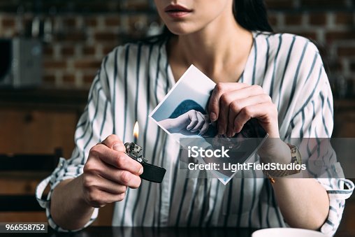 istock cropped shot of young woman burning photo card of ex-boyfriend 966558752