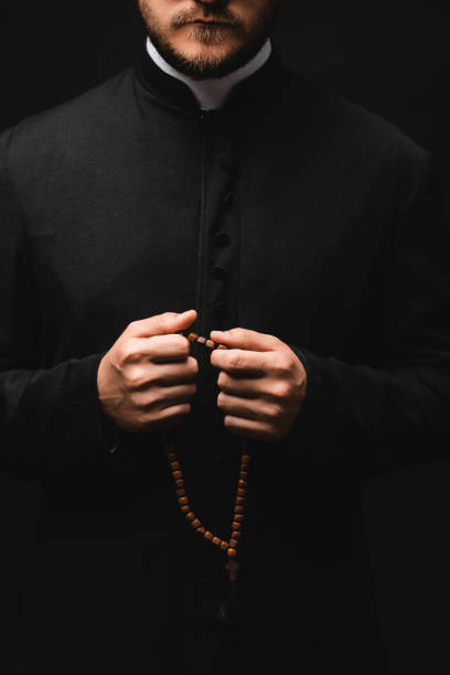 beskuren bild av prästen innehar radband pärlor isolerade på svart - prästkrage bildbanksfoton och bilder
