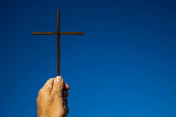 cross on blue background supported by man's hand. cross on blue background supported by man's hand prayer request stock pictures, royalty-free photos & images